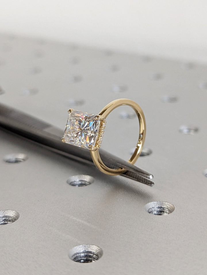 Radiant hidden halo engagement ring finished in polished solid gold