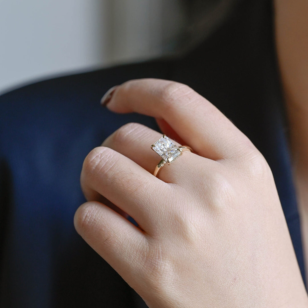 Radiant hidden halo diamond ring displayed on jewelry stand