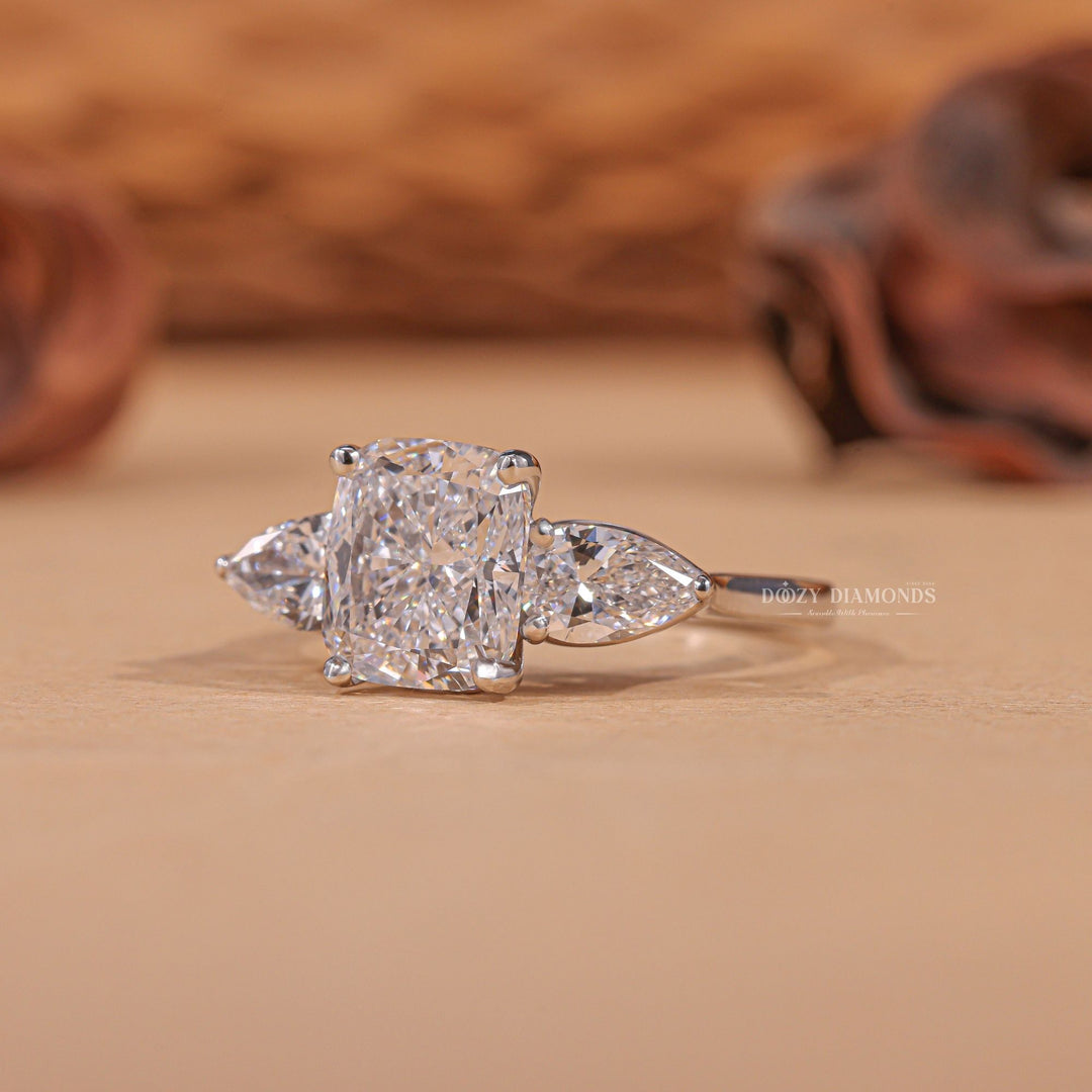 Certified cushion cut diamond featured in three stone engagement ring