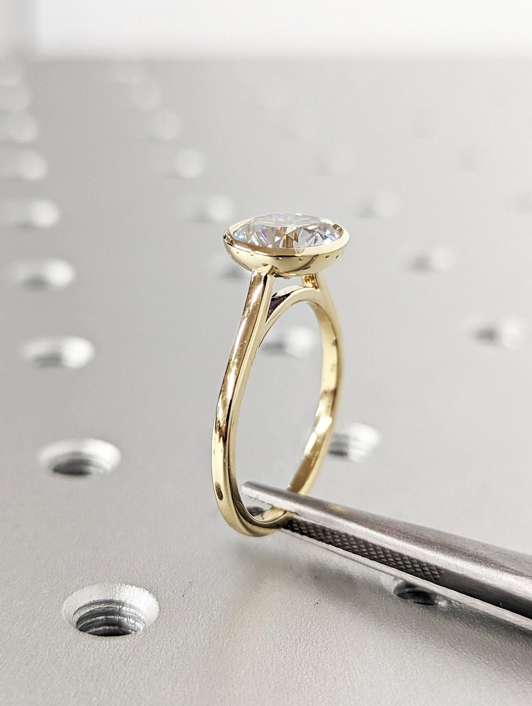 Round bezel lab grown diamond ring fitted on finger