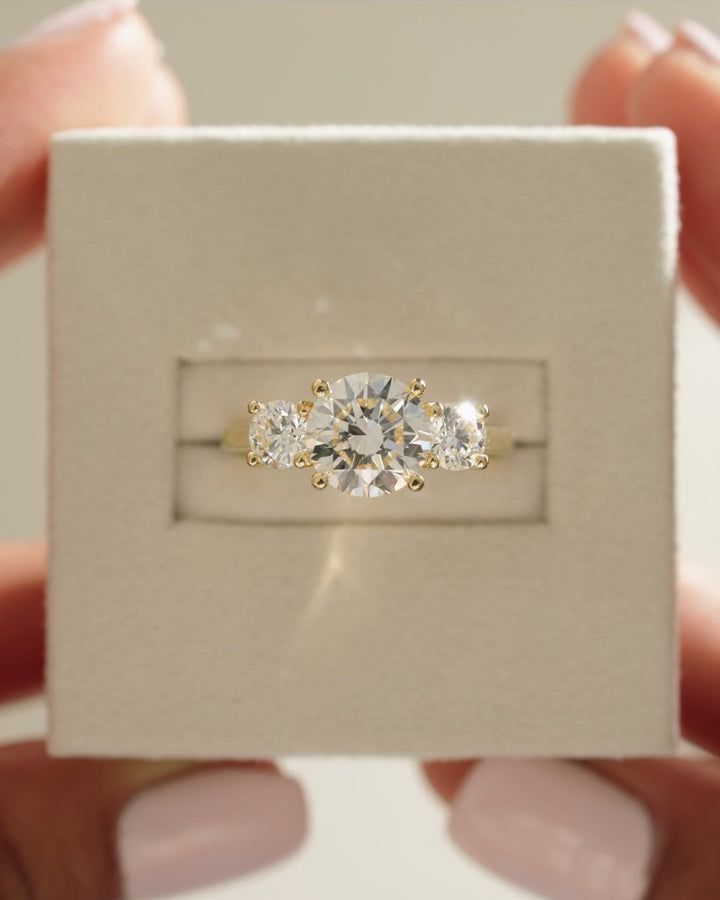 high basket setting, sleek basket setting, refined basket setting, secure basket mounting, elegant row setting, diamond trio setting, linear three stone setting, straight line setting, multi stone linear