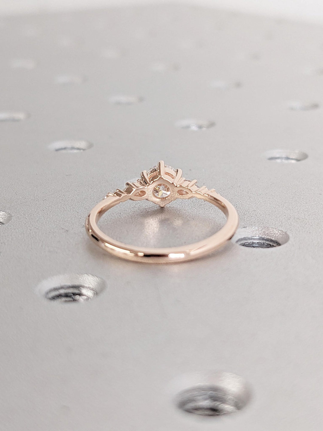 Round cluster diamond ring displayed on jewelry stand