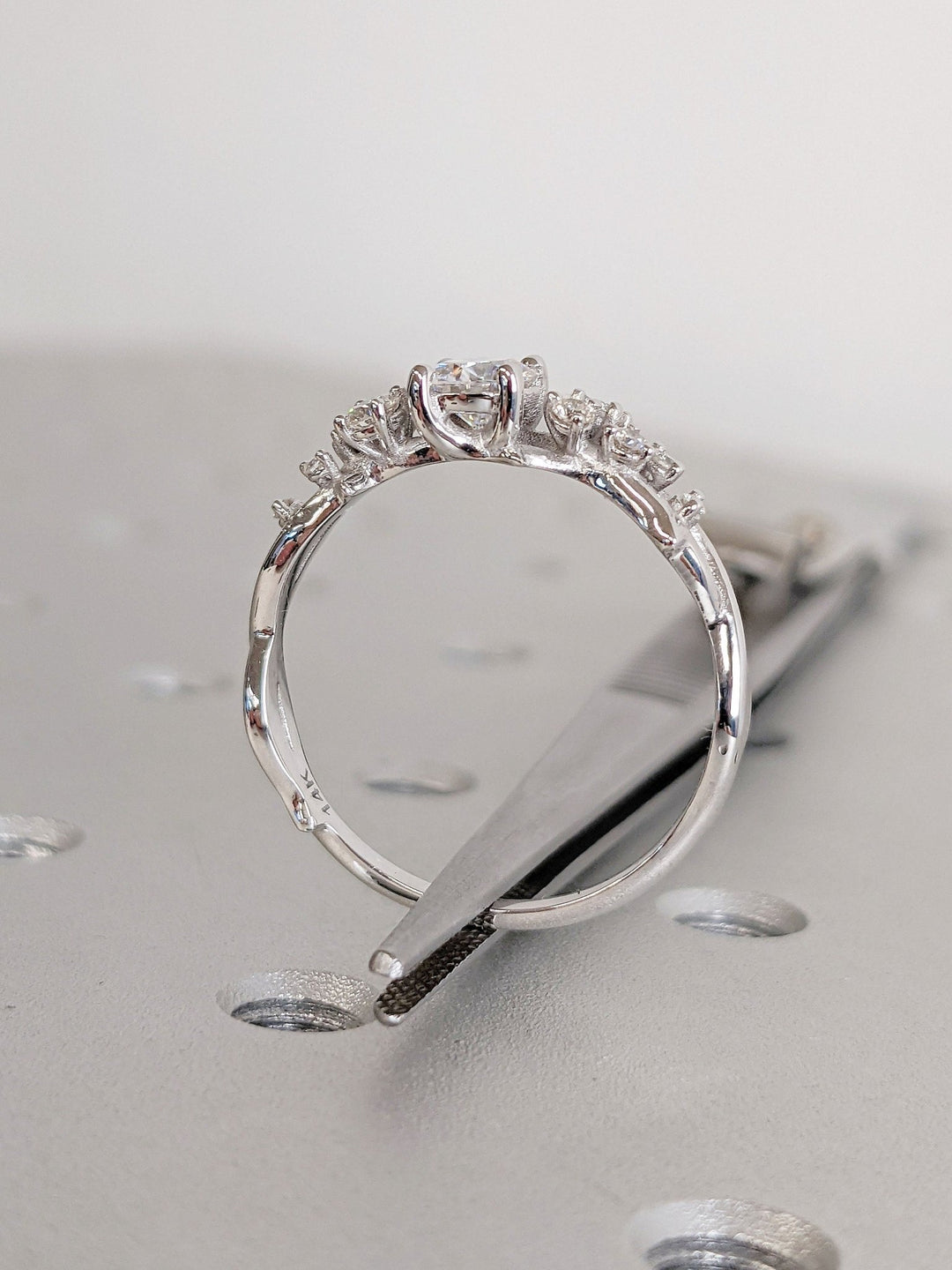 IGI certified round cut diamond in cluster engagement ring setting