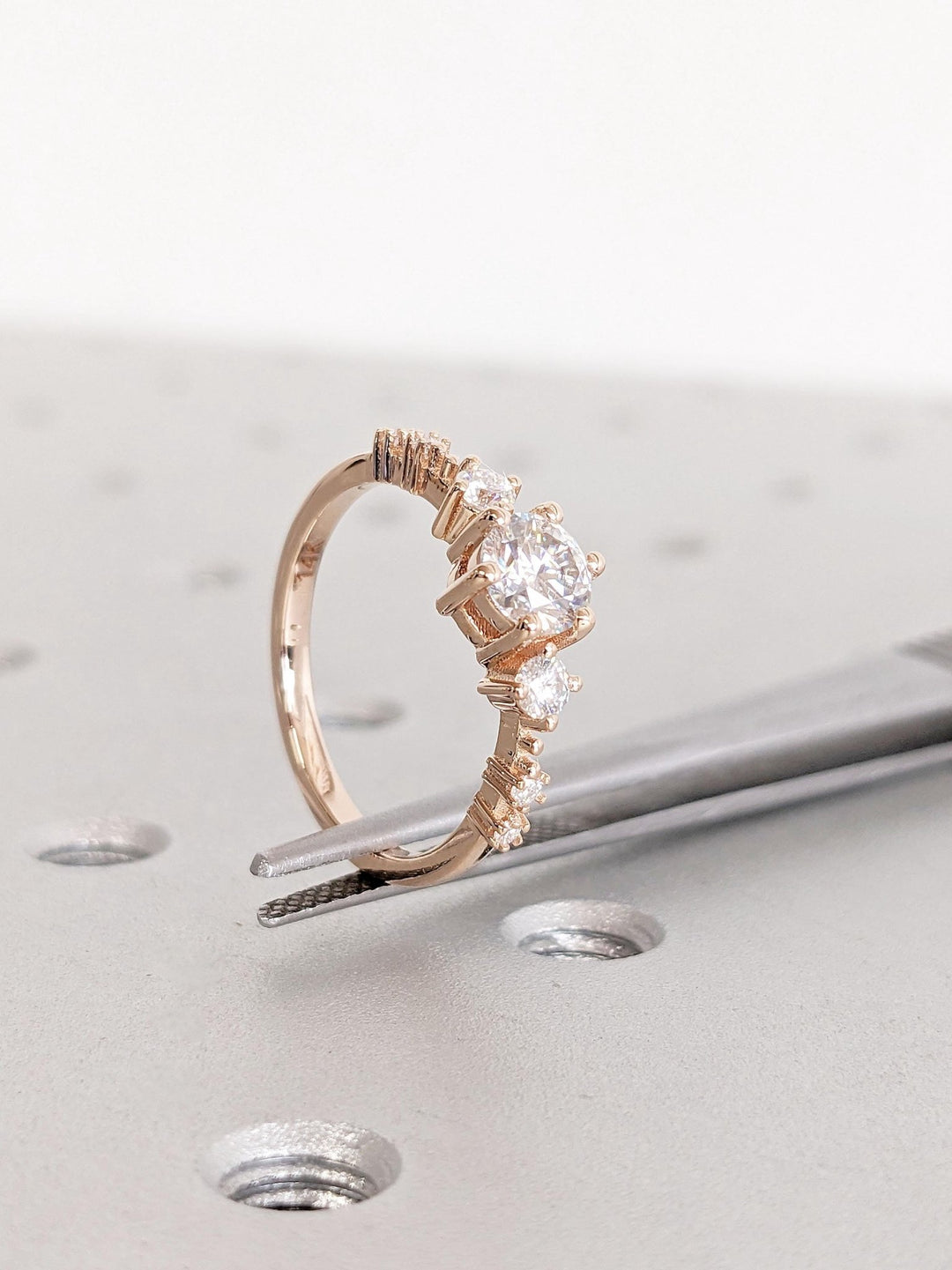 Round cluster engagement ring photographed in natural light