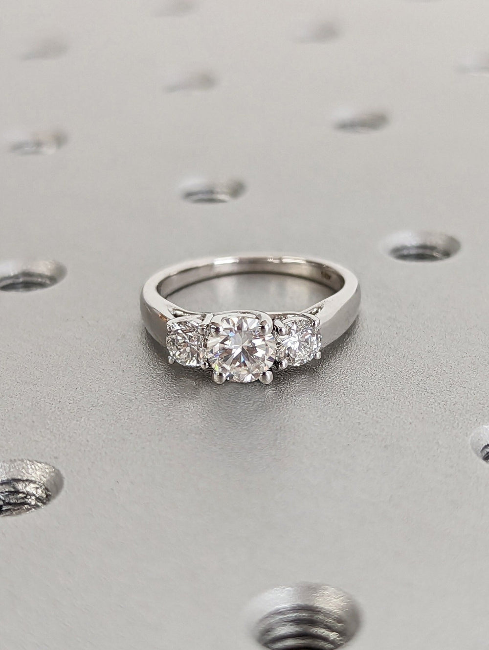 Round three stone diamond ring presented in signature gift packaging