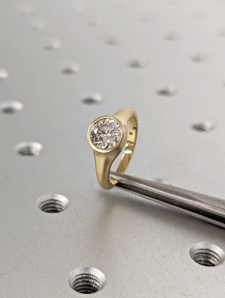 Round cut bezel engagement ring shown in real-life wear