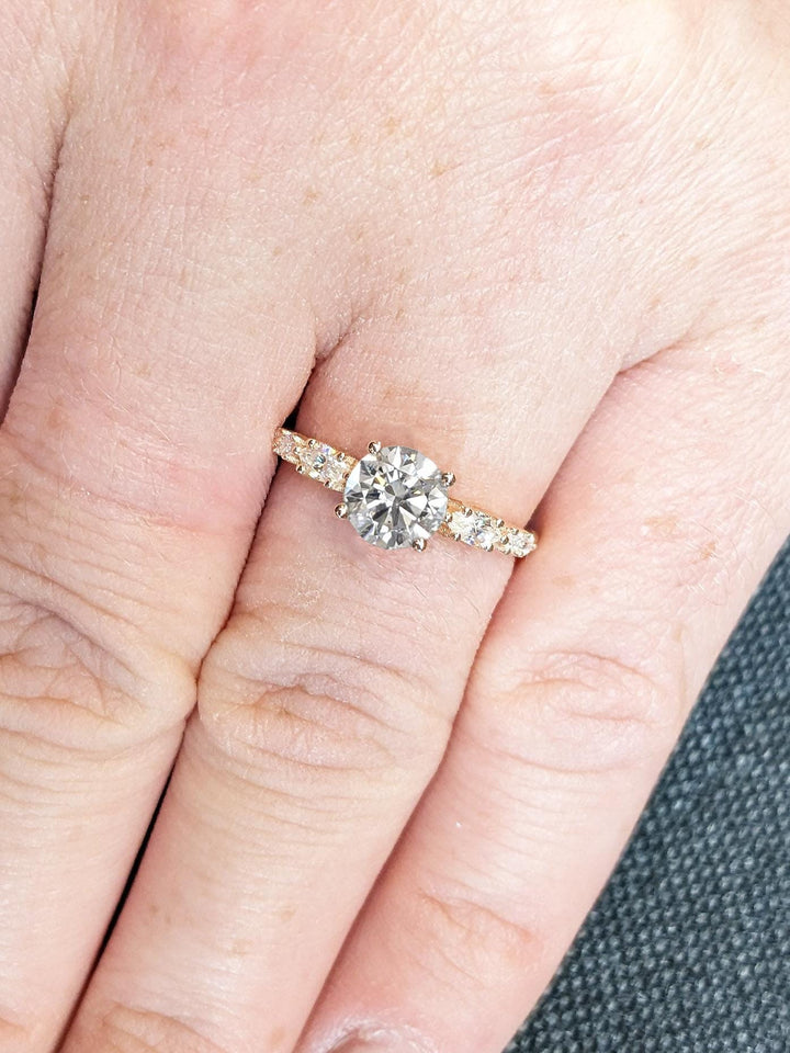 Profile view of round cut cluster engagement ring band