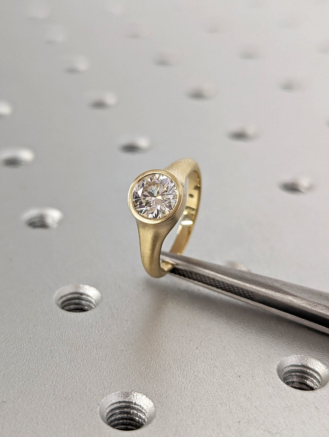 Round bezel lab grown diamond ring side profile in gold setting