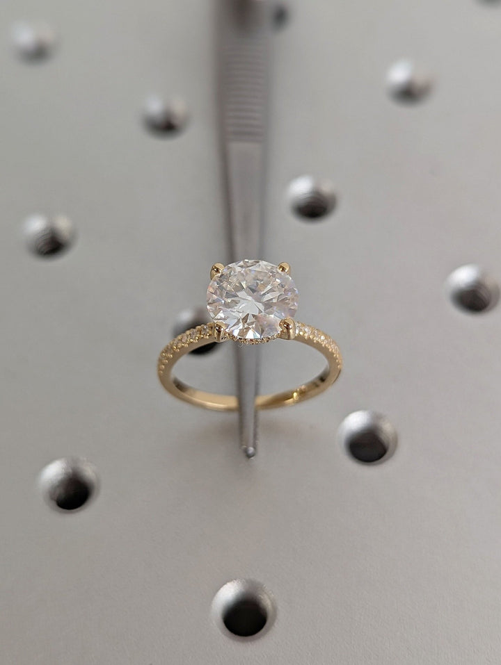 Round hidden halo engagement ring finished in polished solid gold