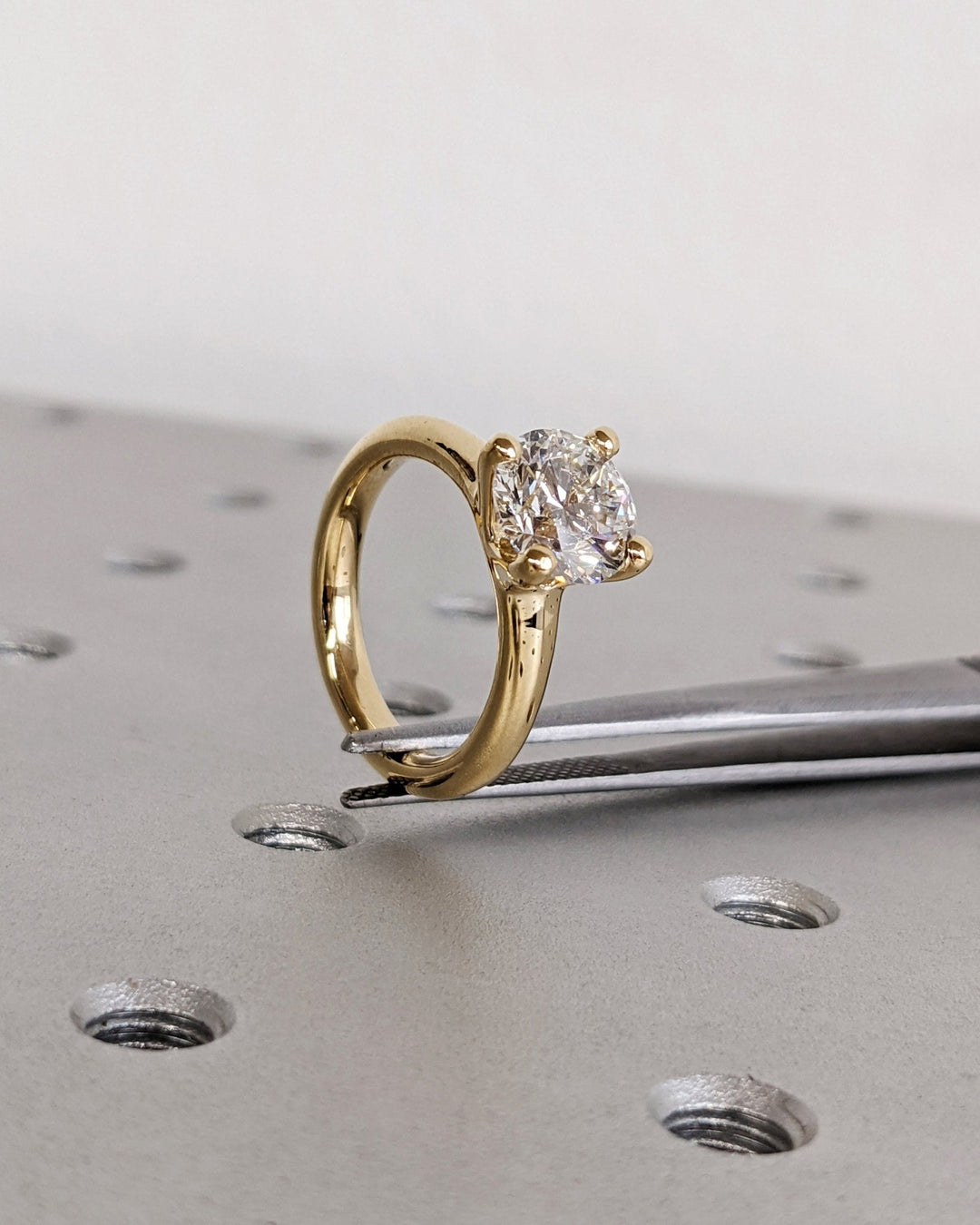 Detailed close-up of round solitaire diamond engagement ring