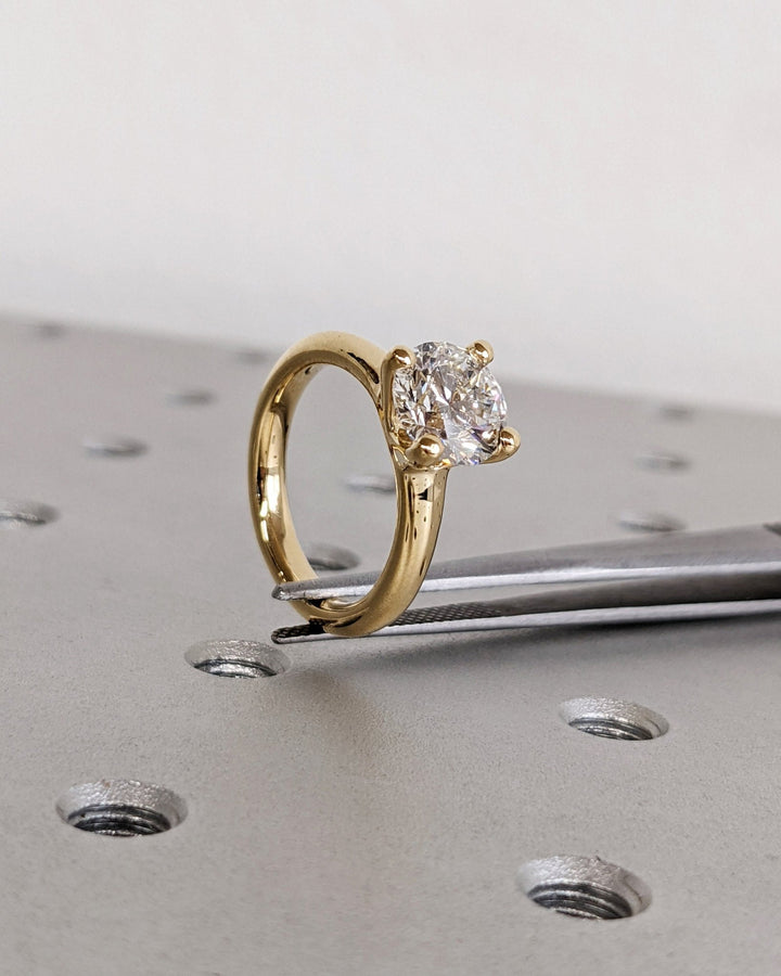 Detailed close-up of round solitaire diamond engagement ring
