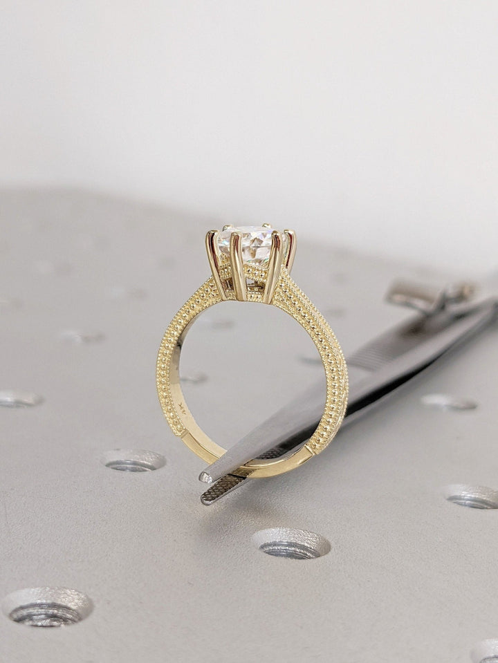 Round vintage engagement ring shown on hand for true-to-life sizing