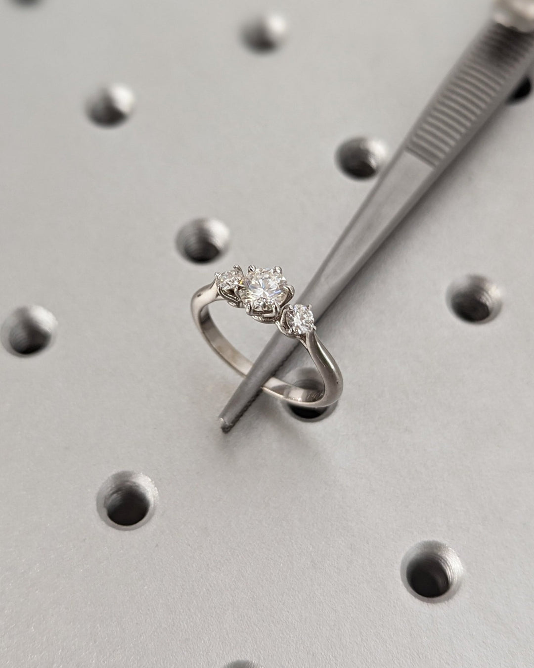 Round three stone engagement ring close-up highlighting diamond sparkle