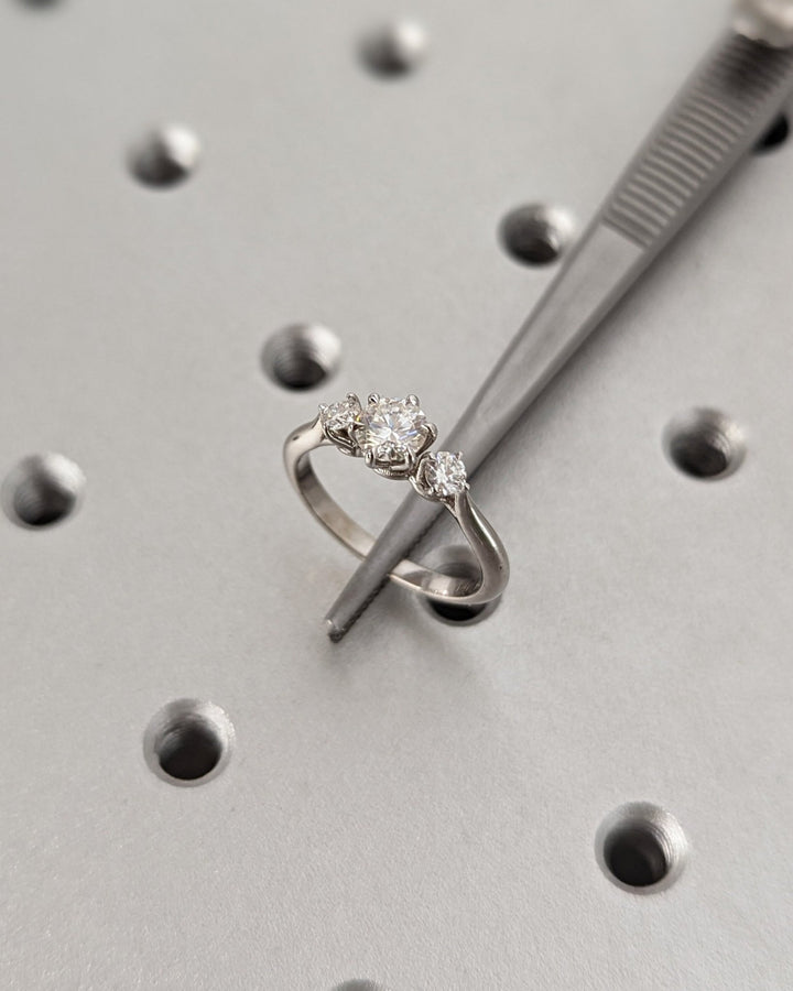 Round three stone engagement ring close-up highlighting diamond sparkle