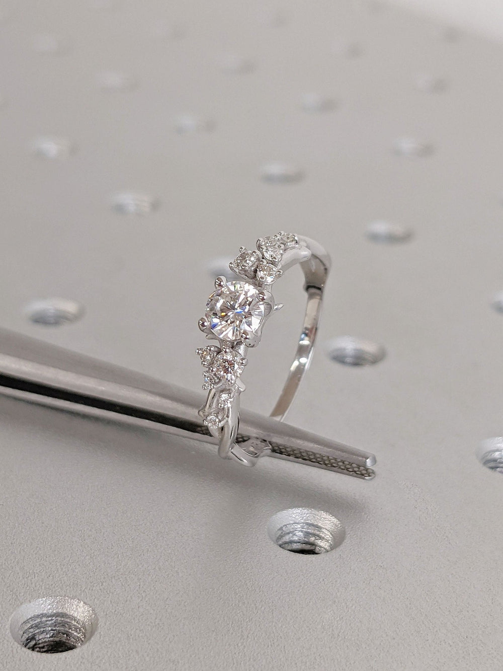 Round cut cluster engagement ring shown in real-life wear