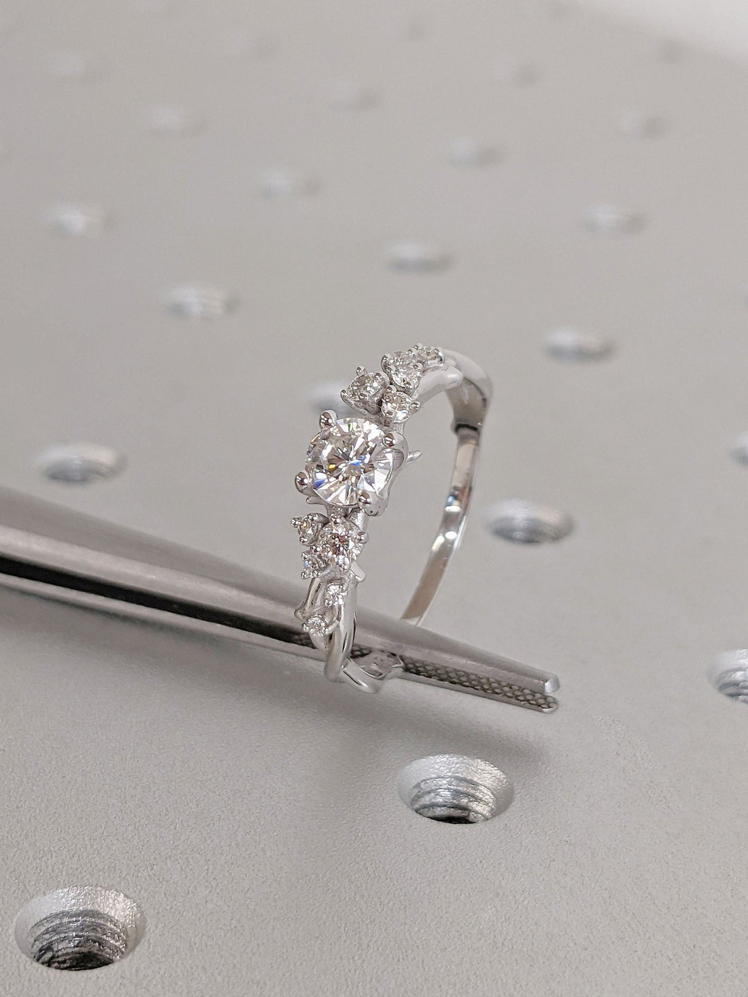 Round cut cluster engagement ring shown in real-life wear