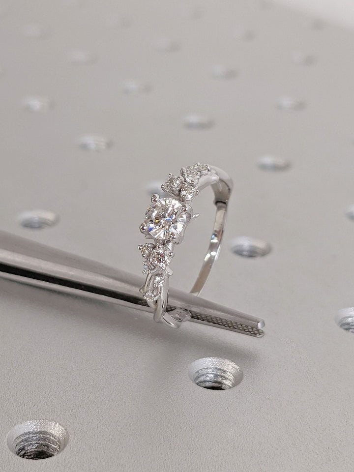 Round cut cluster engagement ring shown in real-life wear