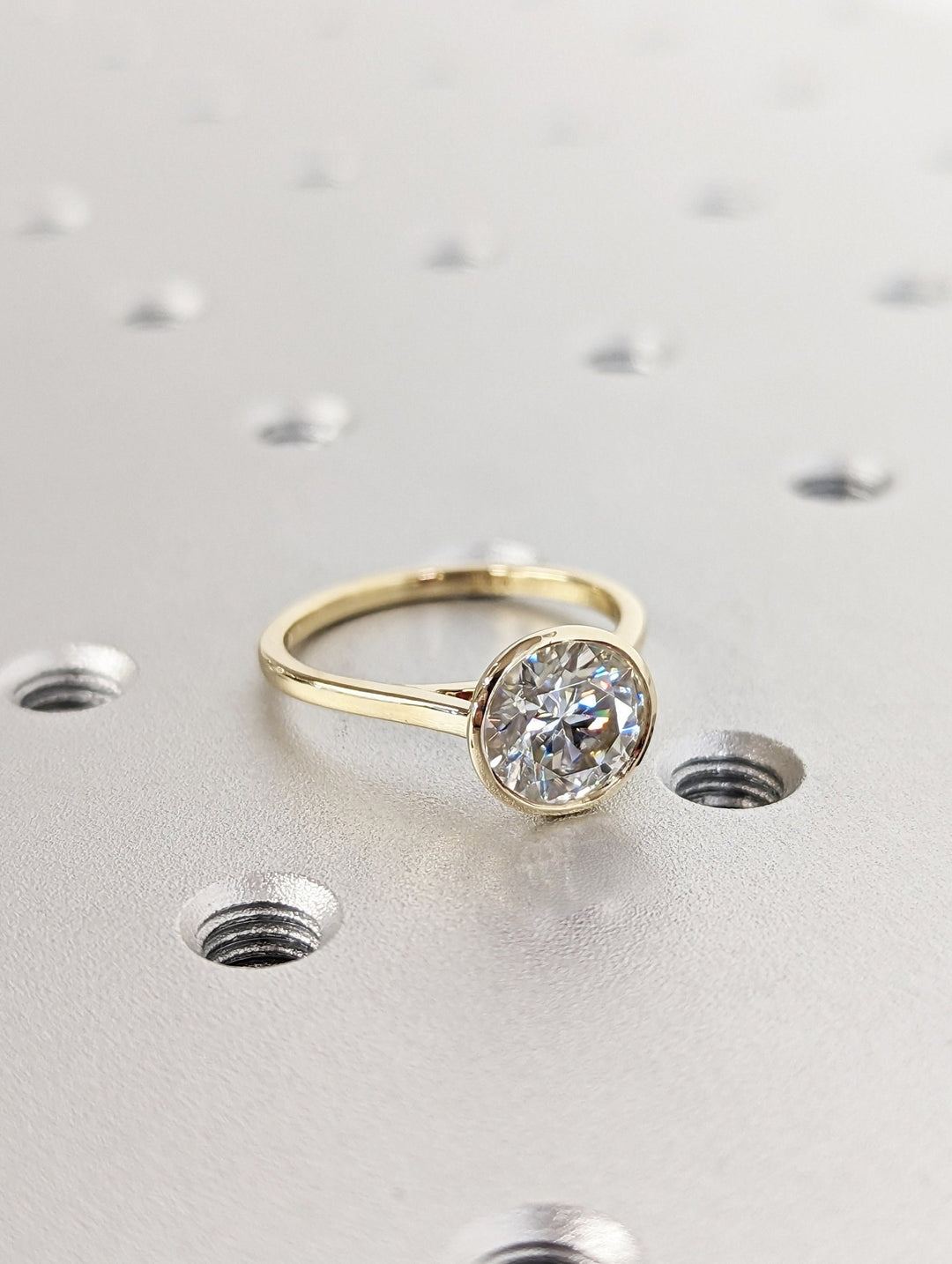 Profile view of round cut bezel engagement ring band