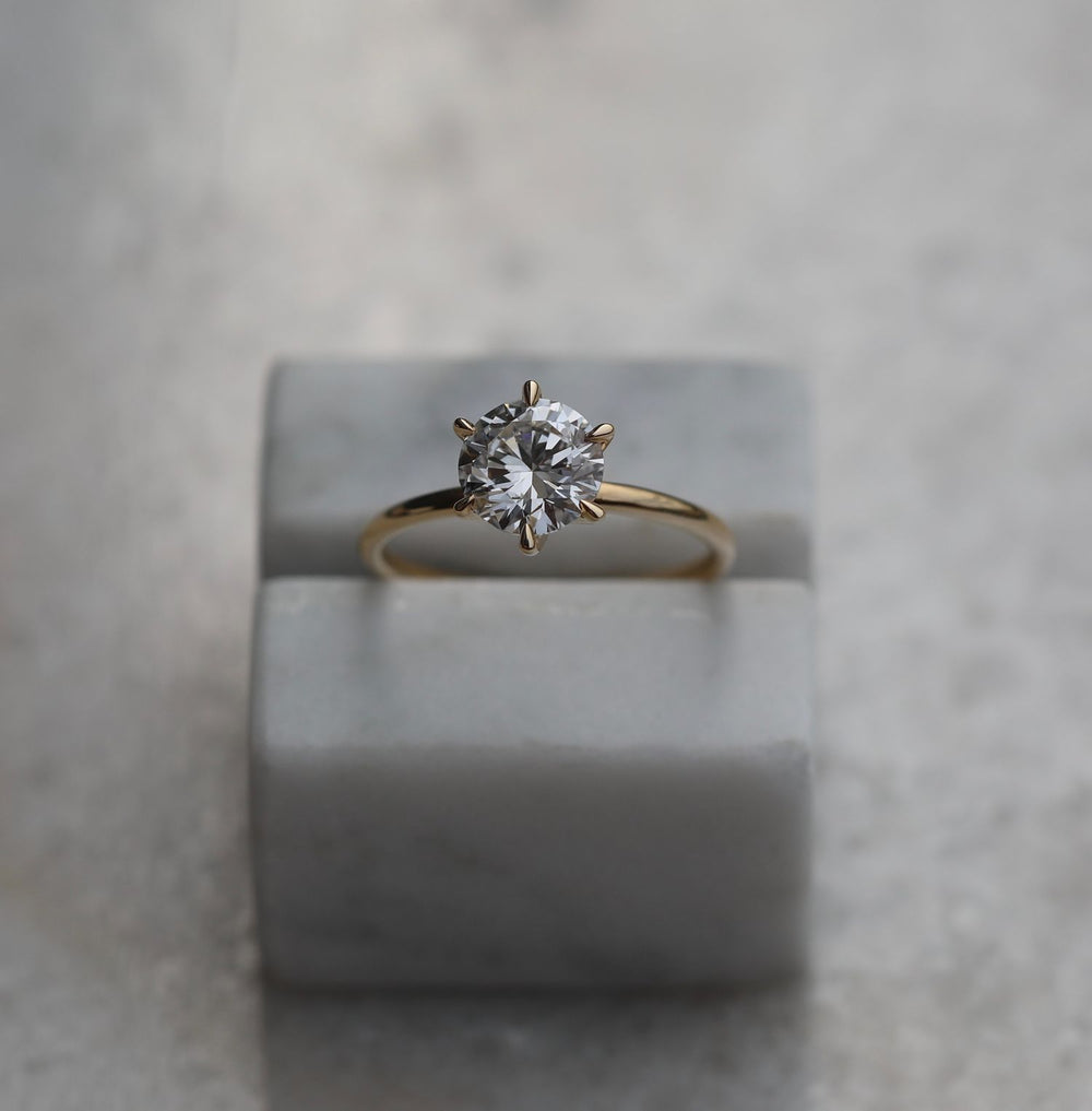 Round solitaire engagement ring photographed in natural light
