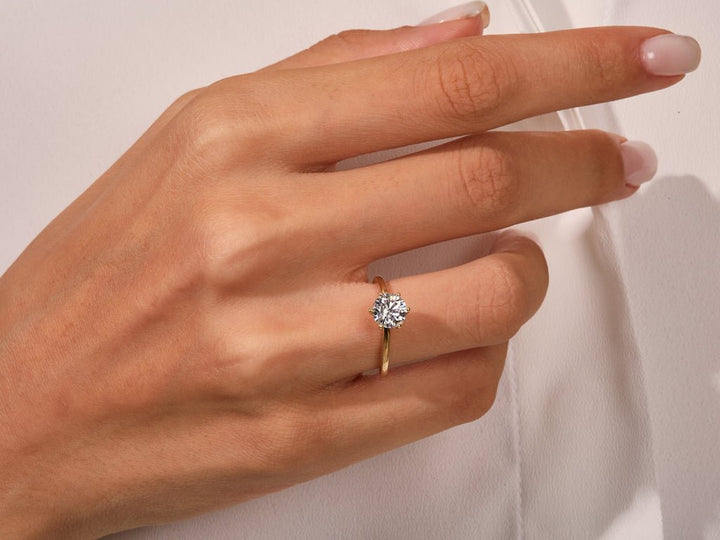 Round solitaire engagement ring finished in polished solid gold
