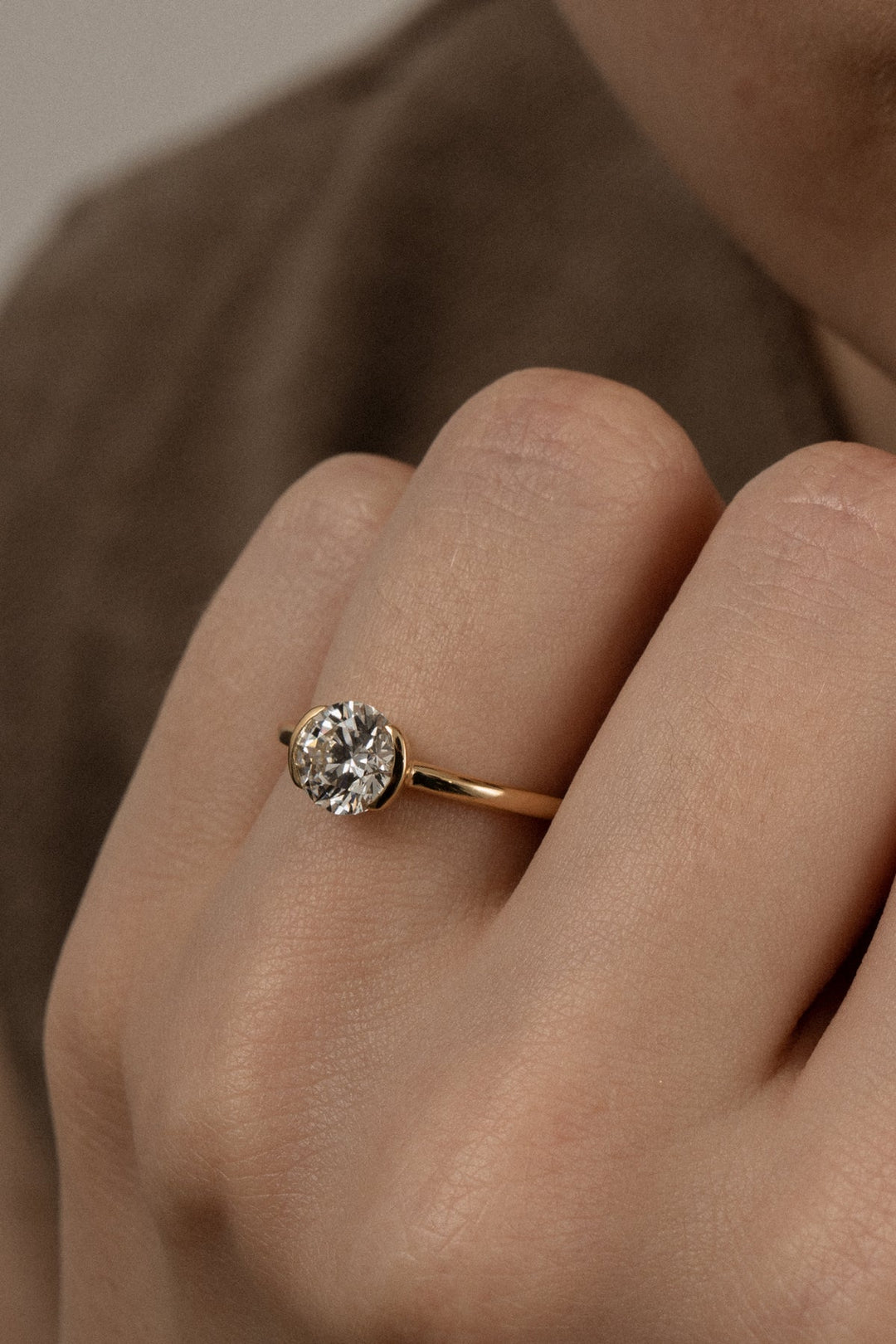 Round bezel diamond ring displayed on jewelry stand