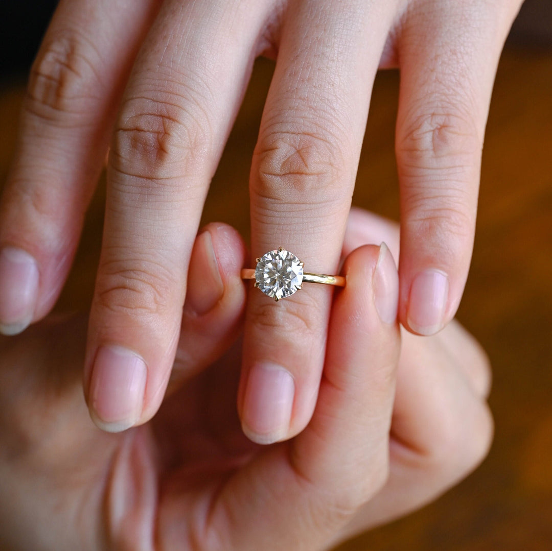Round cut diamond ring worn on hand