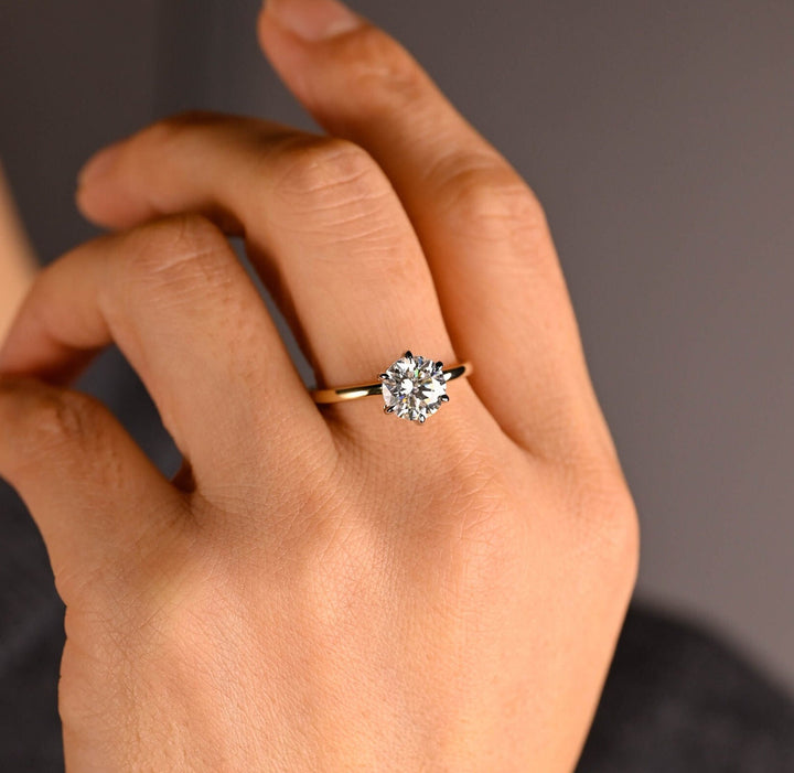 Round hidden halo engagement ring photographed in natural light
