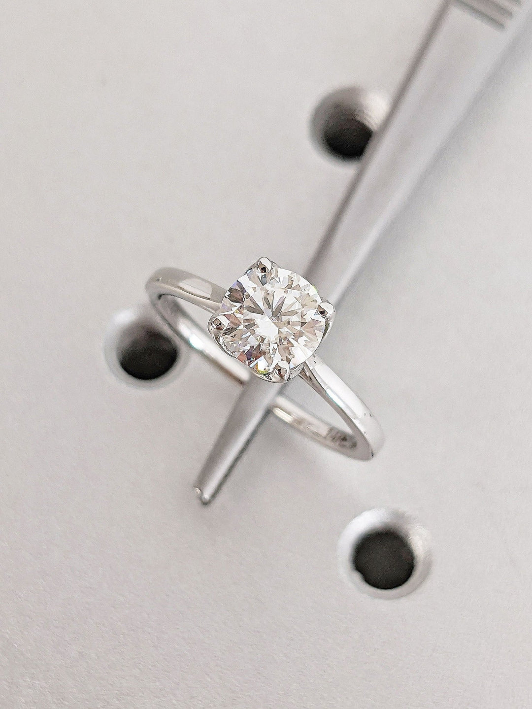Detailed close-up of round solitaire diamond engagement ring