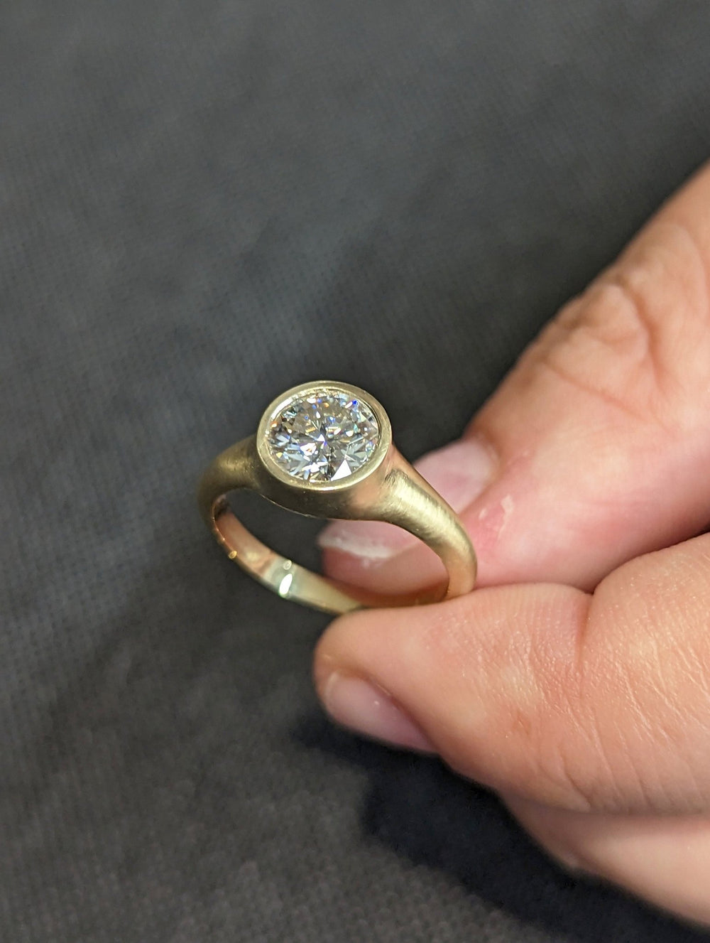 Round bezel engagement ring close-up showing high clarity diamond clarity