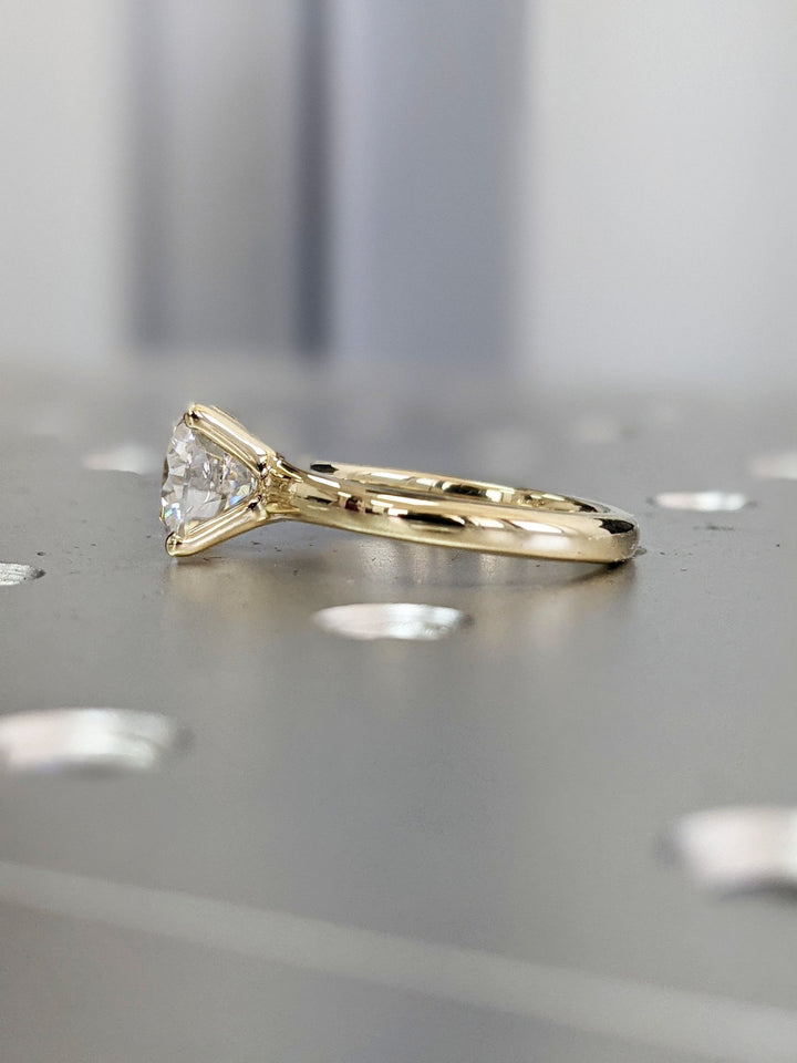 Round solitaire engagement ring viewed from the side