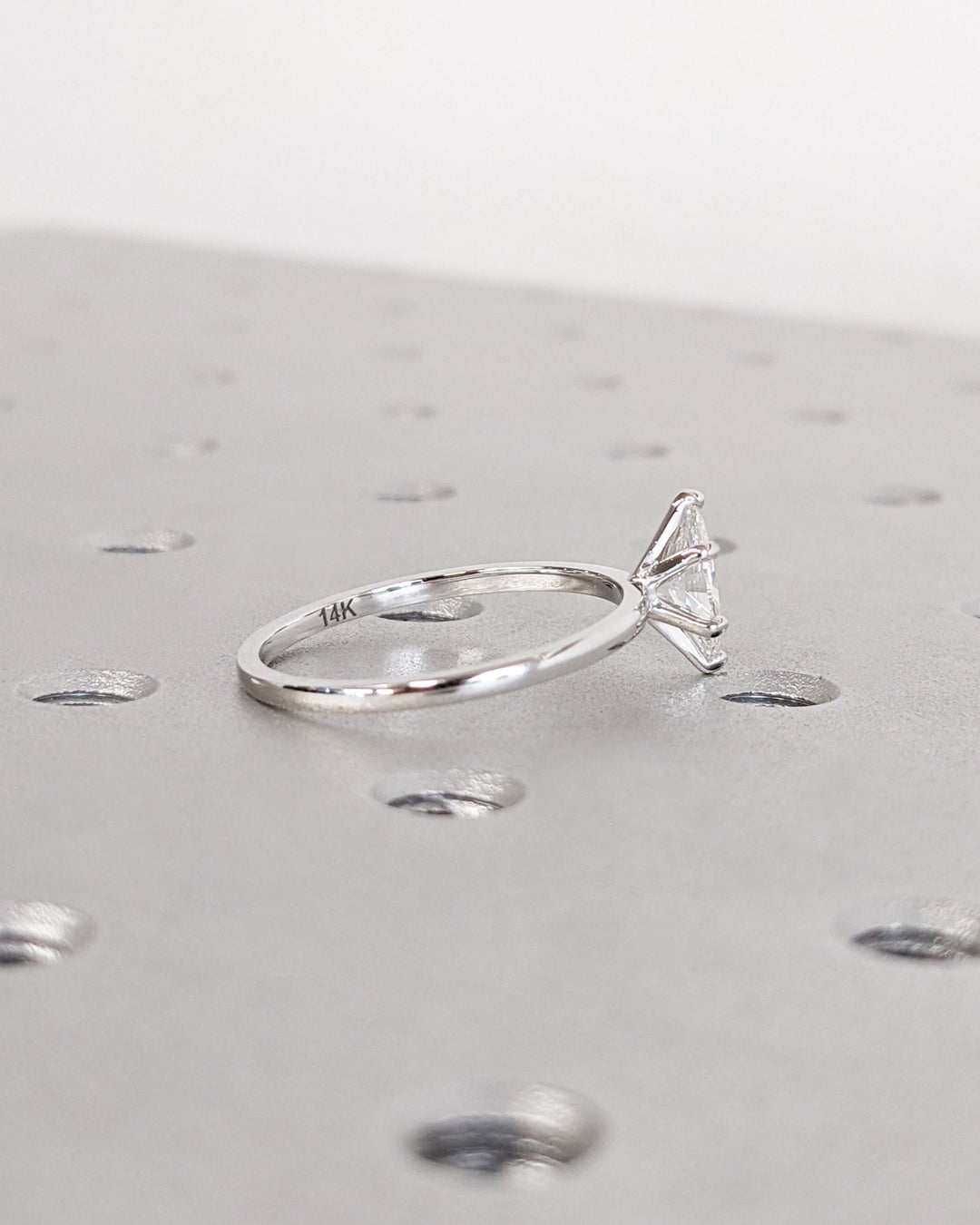 Marquise solitaire engagement ring shown on hand for true-to-life sizing
