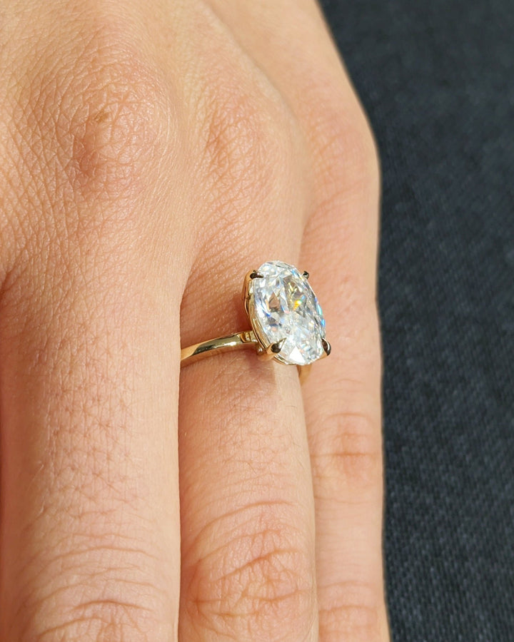 Oval solitaire engagement ring shown on hand for true-to-life sizing