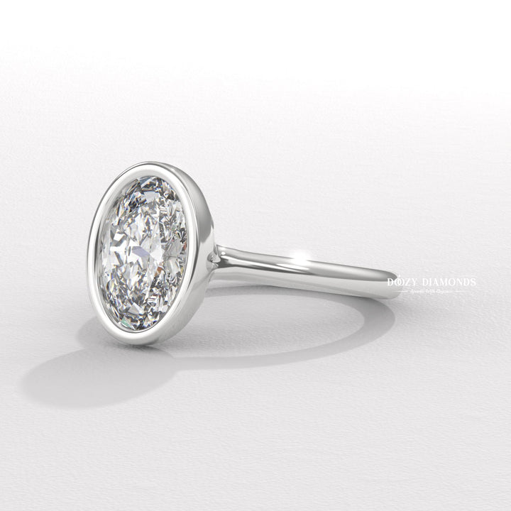 Oval bezel engagement ring finished in polished solid gold