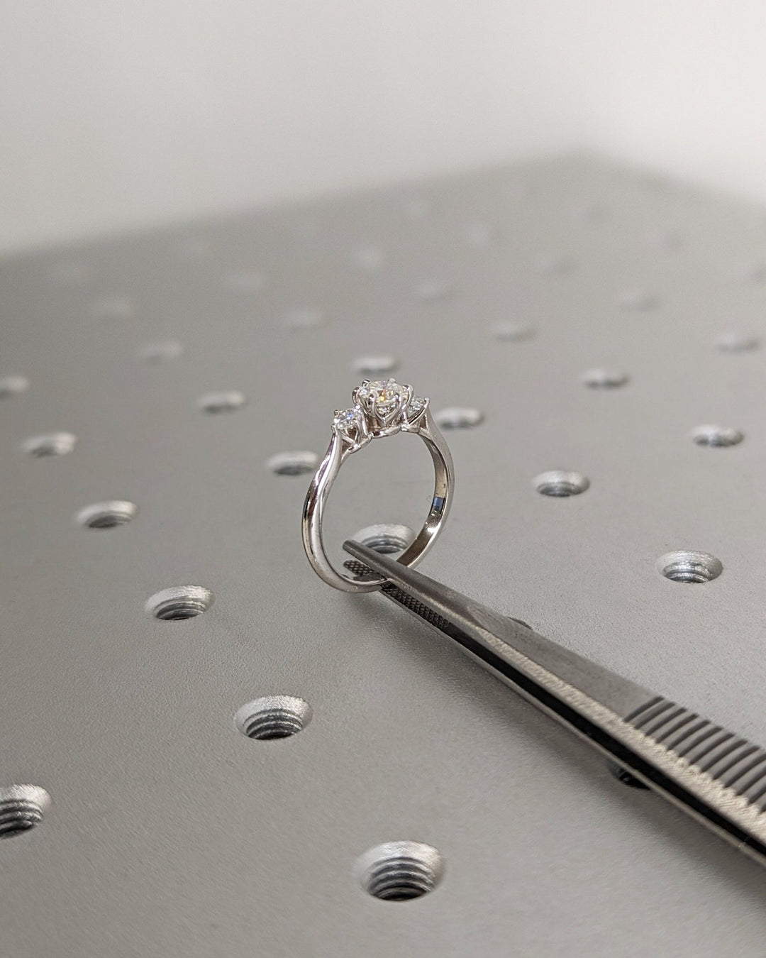 Close-up of round cut center diamond in three stone engagement ring