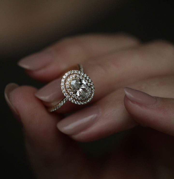 Lifestyle shot of oval halo diamond ring on hand