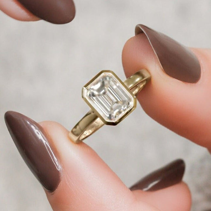 Emerald bezel engagement ring offered in gold and platinum