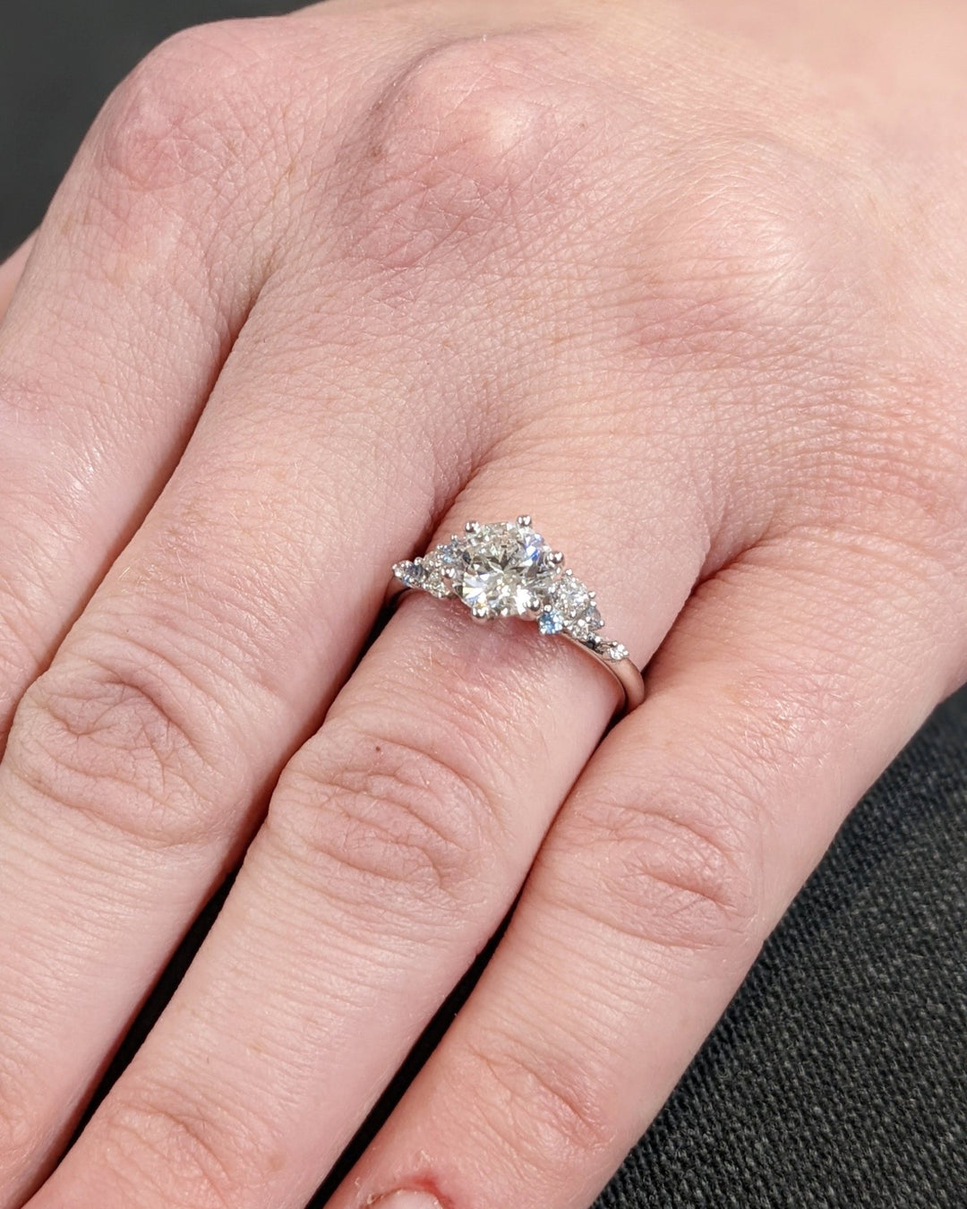 Profile view of round cut cluster engagement ring band