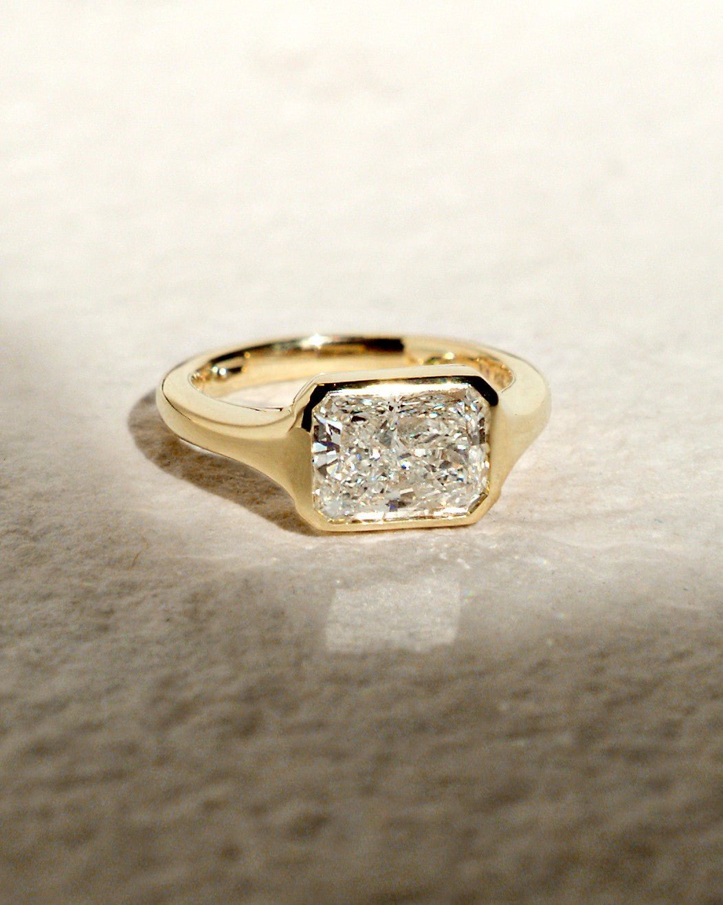 Macro shot of radiant cut diamond facets in bezel ring setting