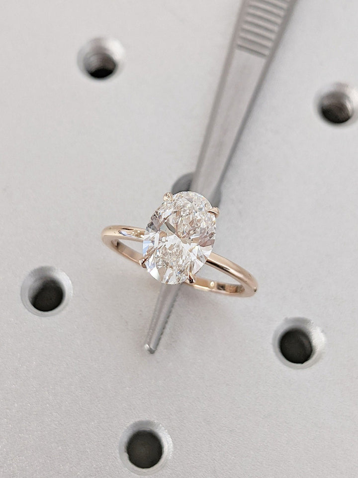 Certified oval cut diamond featured in hidden halo engagement ring