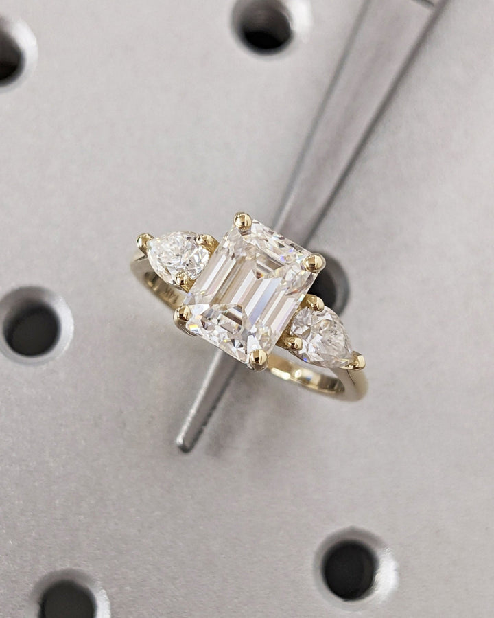Profile view of emerald cut three stone engagement ring band