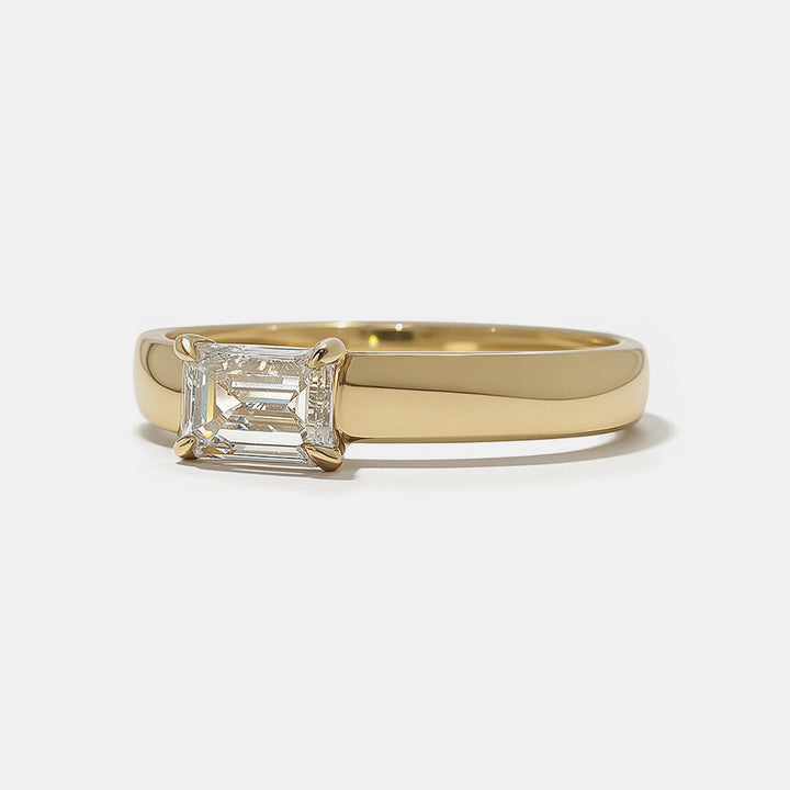 Emerald east west engagement ring finished in polished solid gold