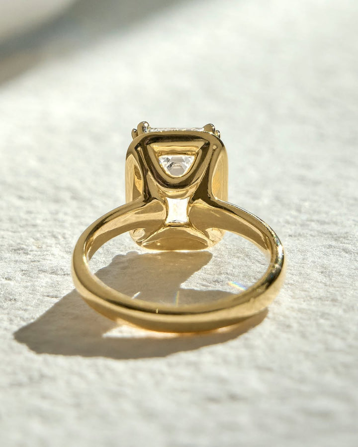 Emerald bezel engagement ring finished in polished solid gold
