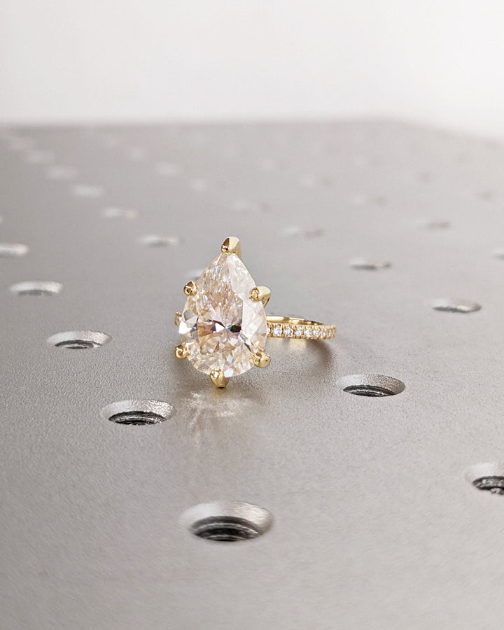 Pear hidden halo engagement ring finished in polished solid gold