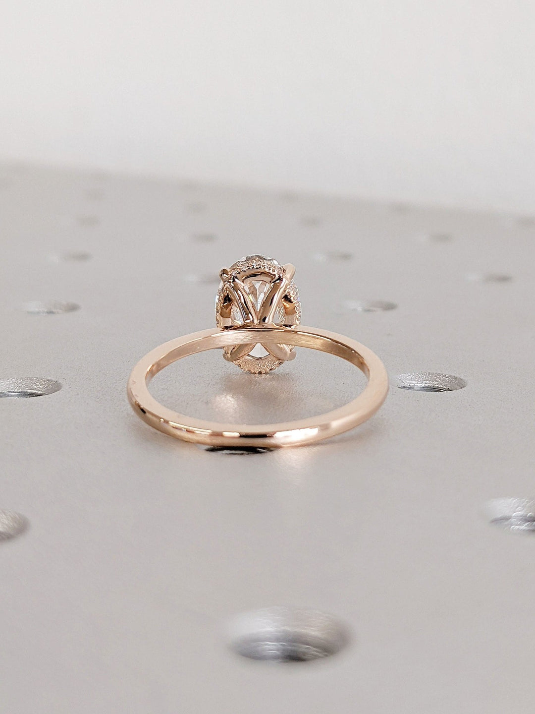 Oval hidden halo engagement ring shown on hand for true-to-life sizing