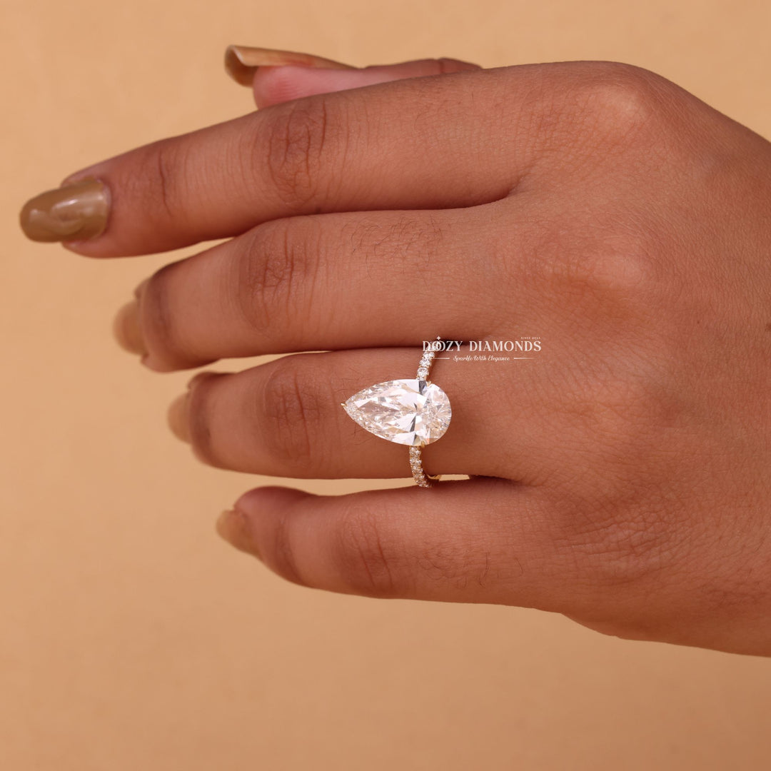 Pear hidden halo engagement ring shown on hand for true-to-life sizing