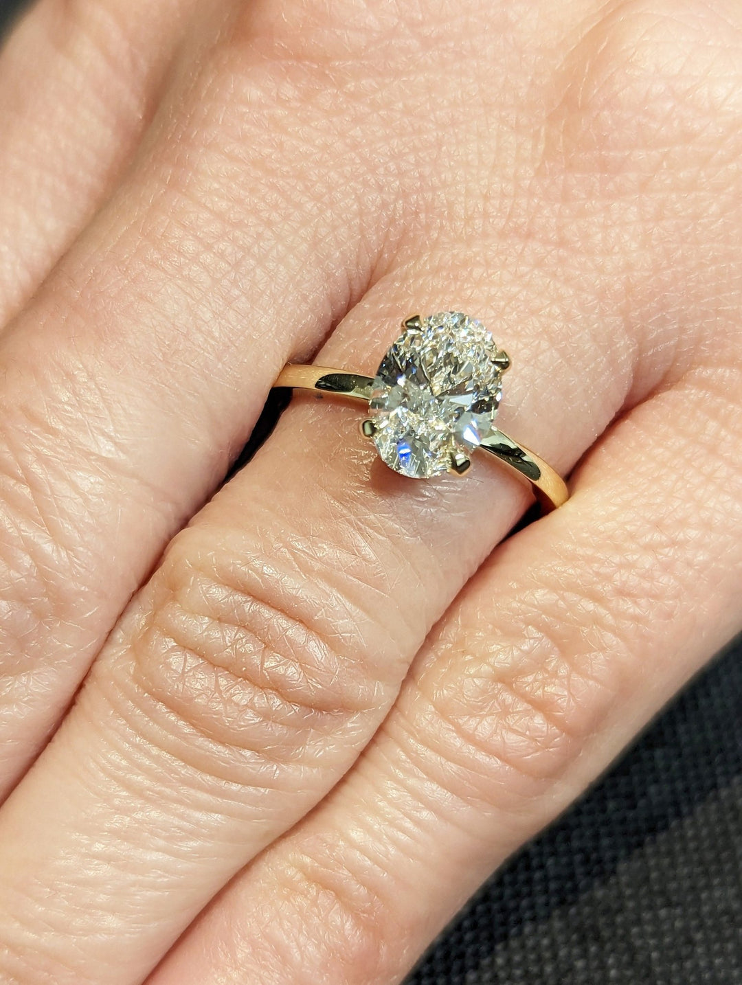 Oval cut solitaire engagement ring with IGI certified center diamond