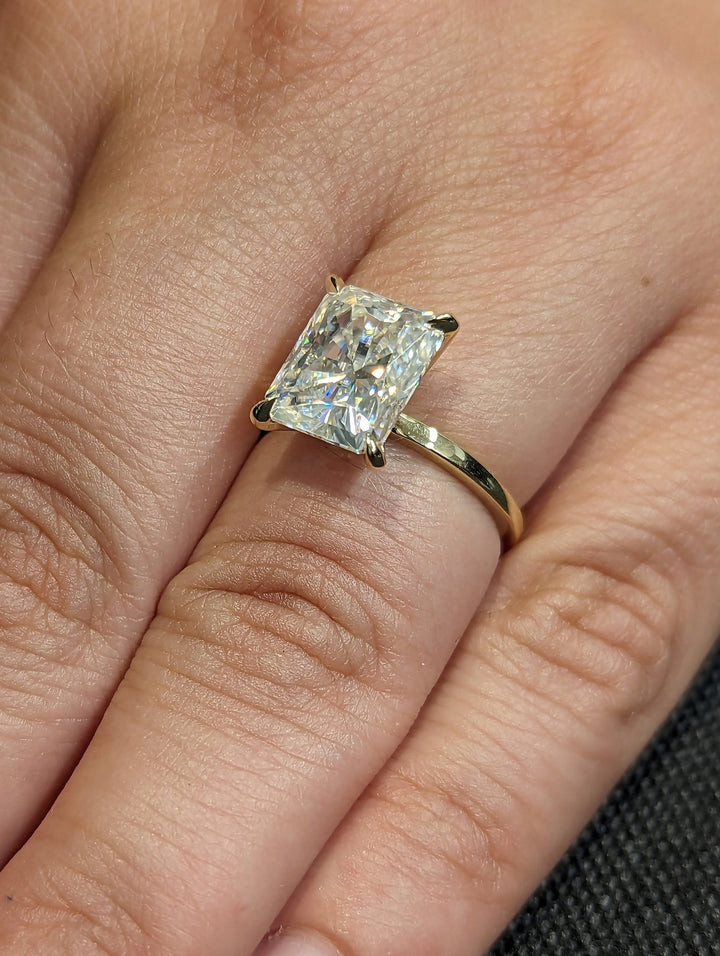 Radiant solitaire engagement ring shown on hand for true-to-life sizing