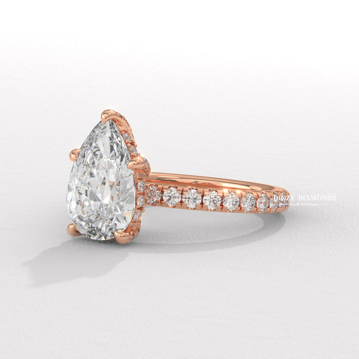 Detailed close-up of pear hidden halo diamond engagement ring