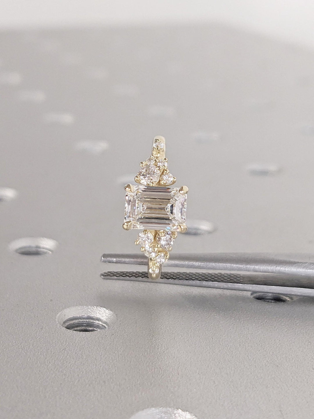Angled view of emerald cut diamond in cluster setting