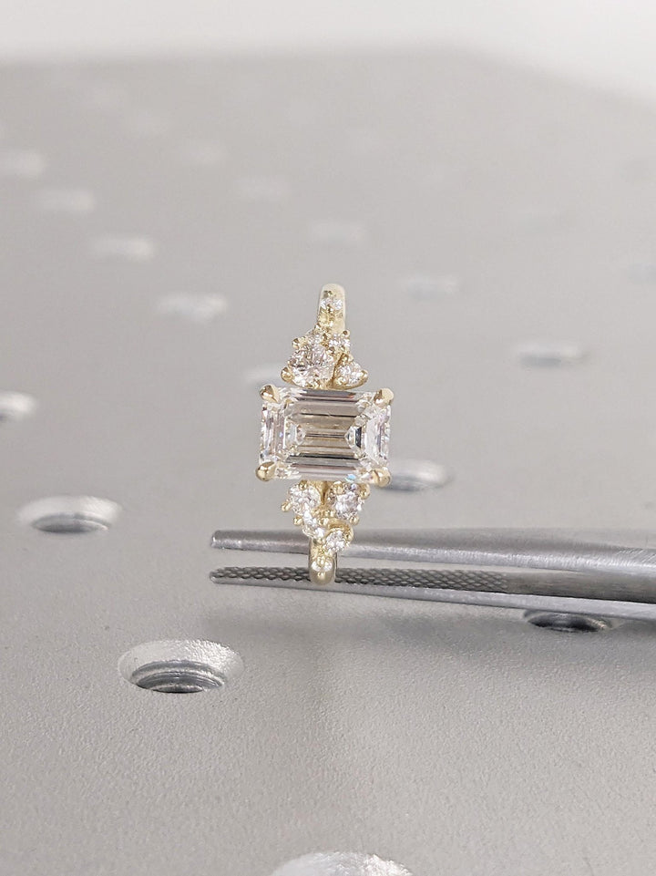 Angled view of emerald cut diamond in cluster setting